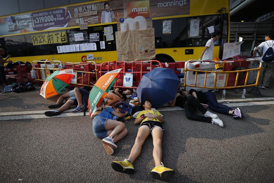 Student activists sleep in the shade of umbrellas, on a road near the government headquarters where pro-democracy activists have gathered and made camp, Tuesday, Sept. 30, 2014, in Hong Kong. (AP Photo/Wong Maye-E)