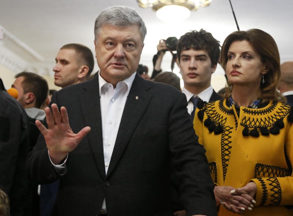 Ukrainian President Petro Poroshenko gestures while speaking to the media as her wife Maryna stands next to him, at a polling station, during the second round of presidential elections in Kiev, Ukraine, Sunday, April 21, 2019. Top issues in the election have been corruption, the economy and how to end the conflict with Russia-backed rebels in eastern Ukraine. (AP Photo/Efrem Lukatsky)