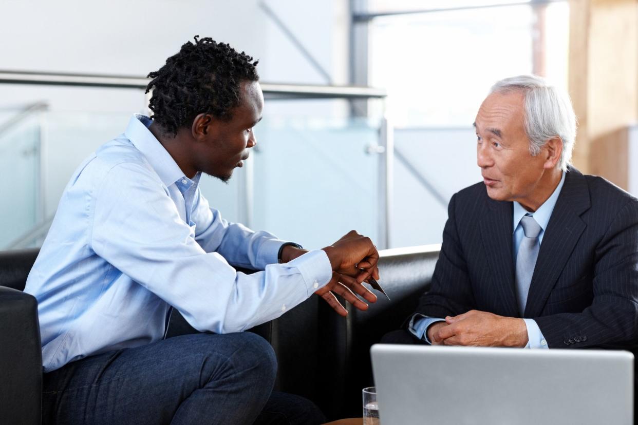 senior man talking to younger businessman