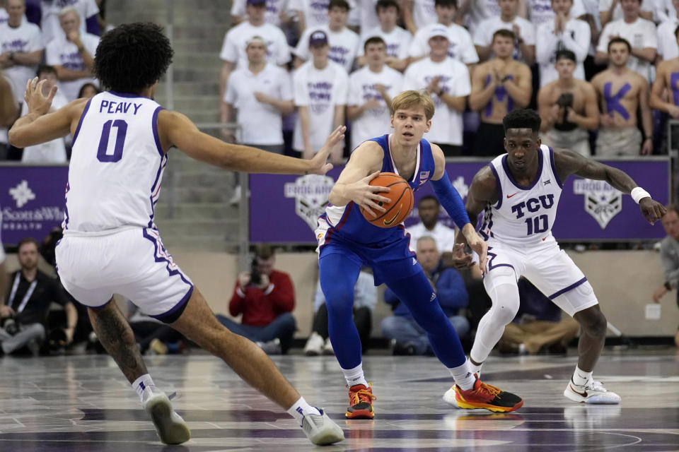 Kansas guard Gradey Dick recovers a loose ball between TCU's Micah Peavy (0) and Damion Baugh (10) in the first half of an NCAA college basketball game, Monday, Feb. 20, 2023, in Fort Worth, Texas. (AP Photo/Tony Gutierrez)