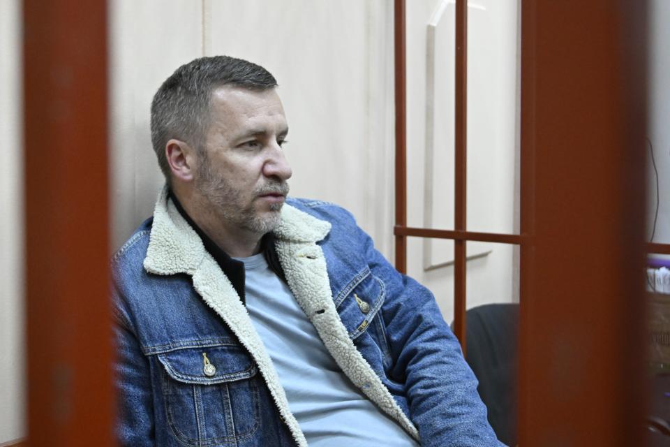 Opposition leader Alexei Navalny's lawyer Igor Sergunin sits in a cage in a courtroom in Moscow, Russia, Friday, Oct. 13, 2023. Russian authorities on Friday detained three lawyers representing imprisoned opposition leader Alexei Navalny after searching their homes, his allies said, a step that comes amid increasing pressure on the Kremlin's critics. (AP Photo/Dmitry Serebryakov)