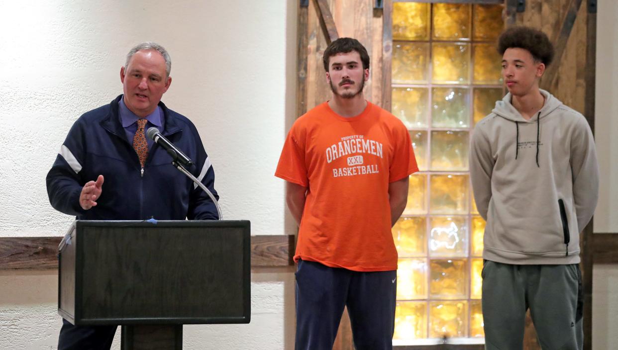 Ellet boys basketball coach Mark Fisher, left, introduces John Moledor and Isaiah Harper during the Akron City Series high school basketball media day at Guy's Party Center on Tuesday in Akron.