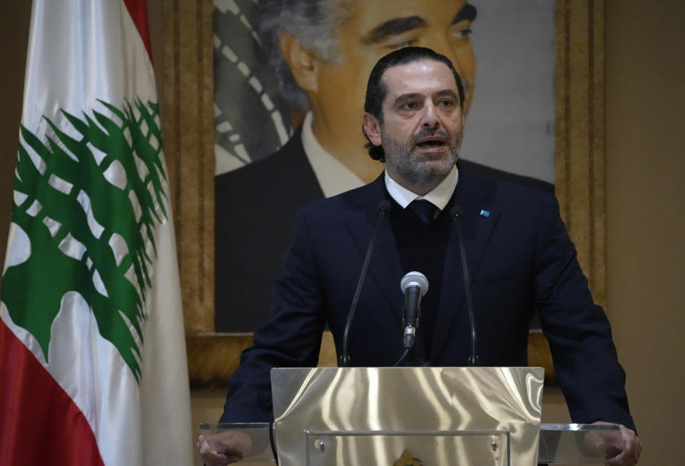 Former Lebanese Prime Minister Saad Hariri speaks during a press conference in front of a picture of his late father and former Prime Minister of Lebanon Rafic Hariri, at his house in downtown Beirut, Lebanon, Monday, Jan. 24, 2022. Hariri said Monday he is suspending his work in politics and will not run in May’s parliamentary elections. (AP Photo/Hussein Malla)