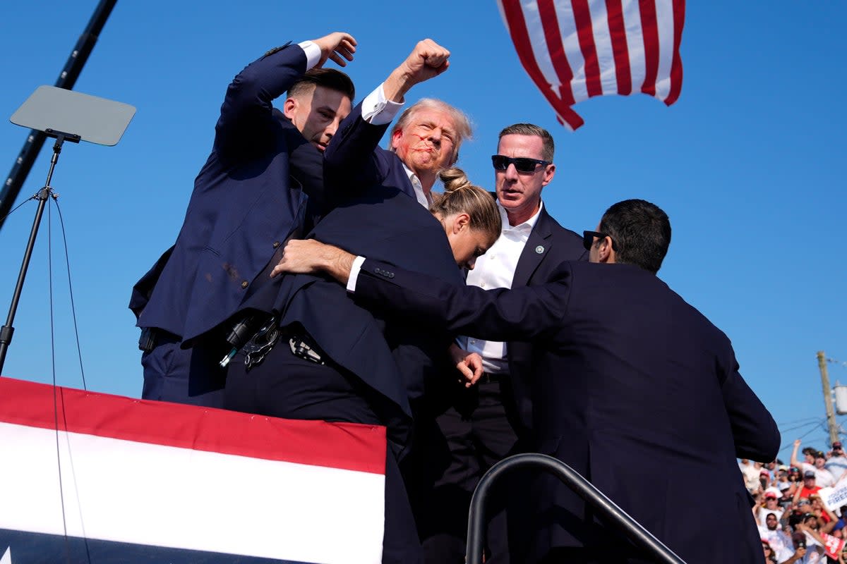 Secret Service agents surround Donald Trump at a campaign rally on Saturday, July 13, 2024, shortly after gunshots (AP)