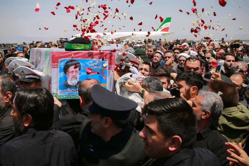 Mourners carry the flag-draped coffins of Iran's late President Ebrahim Raisi, Foreign Minister Hossein Amir-Abdollahian and others who were killed in a helicopter crash on Sunday, during their funeral ceremony in the city of Mashhad. -/Iranian Presidency/dpa