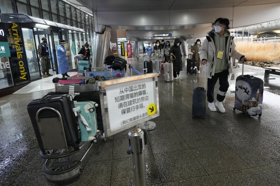 Passengers coming from China pass by a COVID-19 testing center at the Incheon International Airport in Incheon, South Korea, on Jan. 14, 2023. South Korea says it will continue to restrict the entry of short-term travelers from China through the end of February over concerns that the spread of COVID-19 in that country may worsen following the Lunar New Year’s holidays. (AP Photo/Ahn Young-joon)