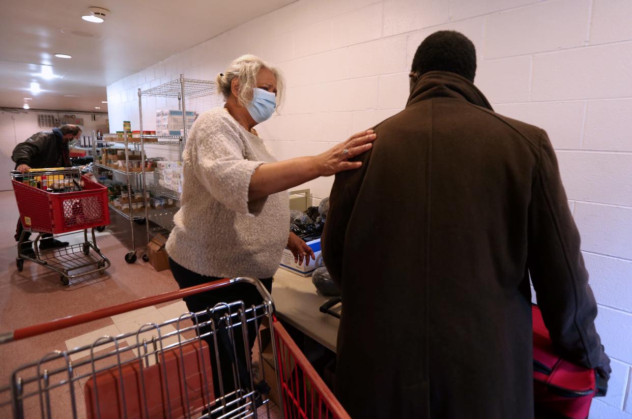 Ascension Wisconsin parish nurse Julia Means, center, helps a client at the food pantry at Ebenezer Health Resource Center. Means became the first parish nurse for Ascension in 1996 and has more than 25 years experience helping to make health care more accessible in Milwaukee.