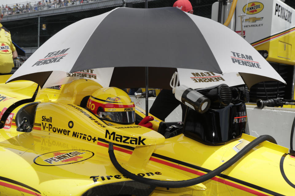 Helio Castroneves, of Brazil, sits in his car under an umbrella during practice for the Indianapolis 500 IndyCar auto race at Indianapolis Motor Speedway, Thursday, May 16, 2019 in Indianapolis. (AP Photo/Michael Conroy)