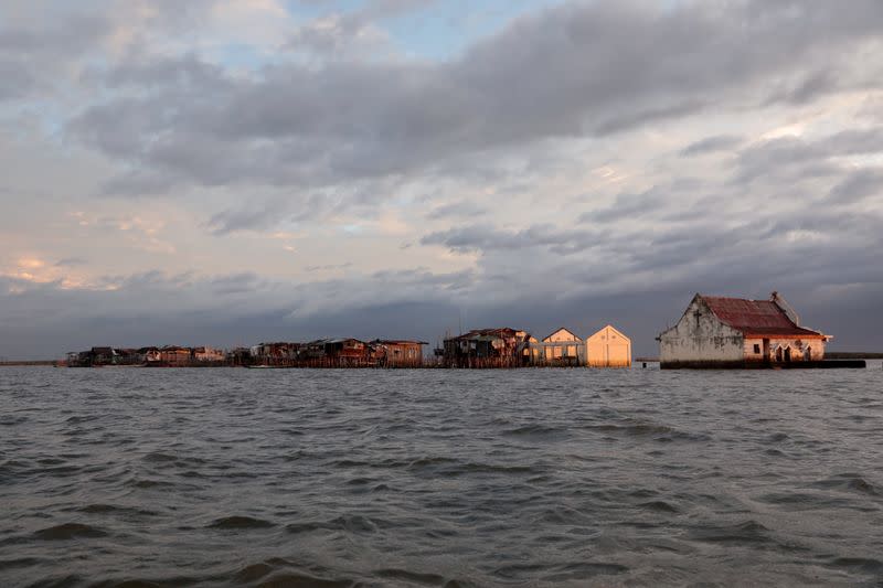 The Wider Image: Rising seas threaten early end for sinking village in Philippines