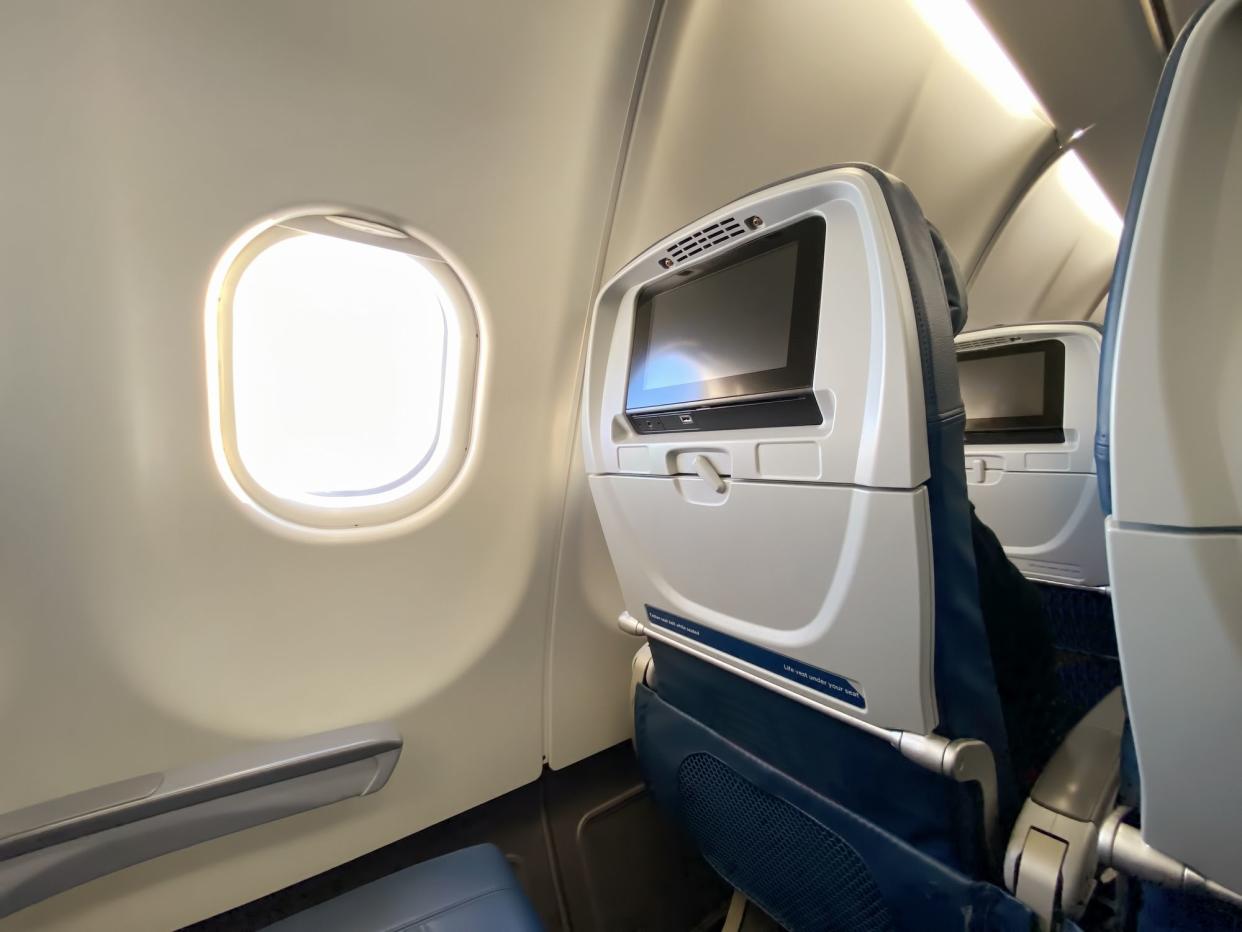 Wide angle shot of an airplane cabin with sunlight coming in from window