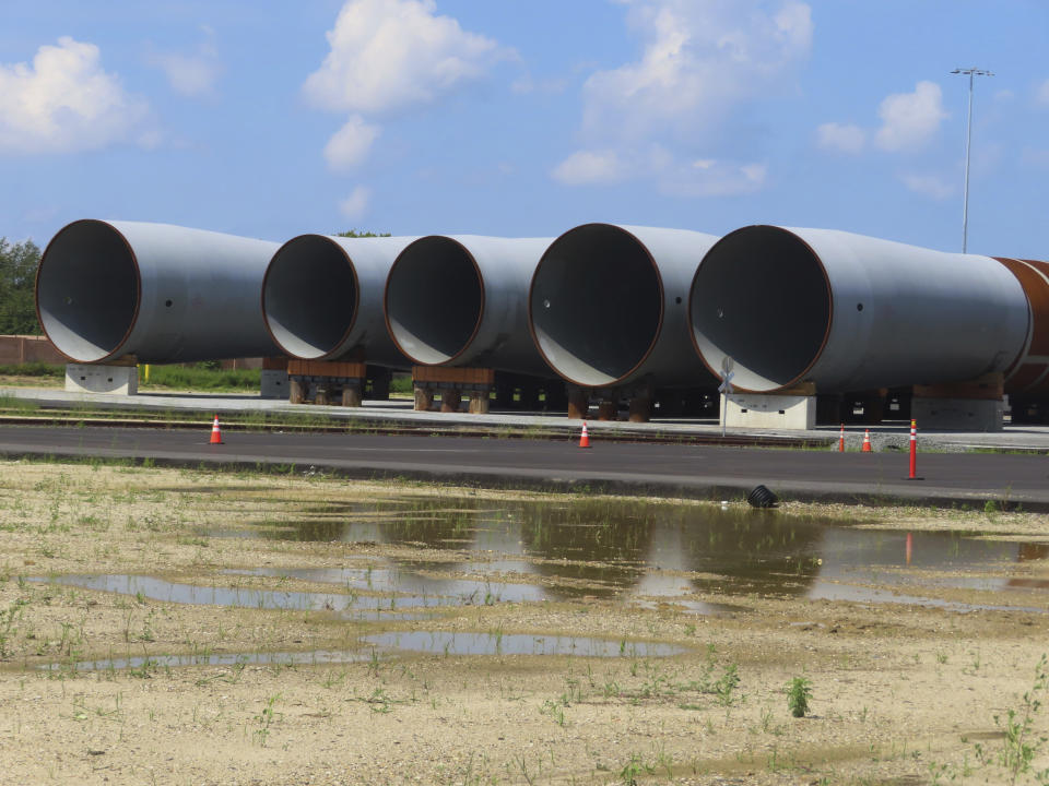 Giant monopiles, the foundations for offshore wind turbines, sit on the ground at the Paulsboro Marine Terminal in Paulsboro, N.J. on Thursday, July 6, 2023, when New Jersey Gov. Phil Murphy planned to sign a bill granting a tax break to offshore wind developer Orsted. (AP Photo/Wayne Parry)