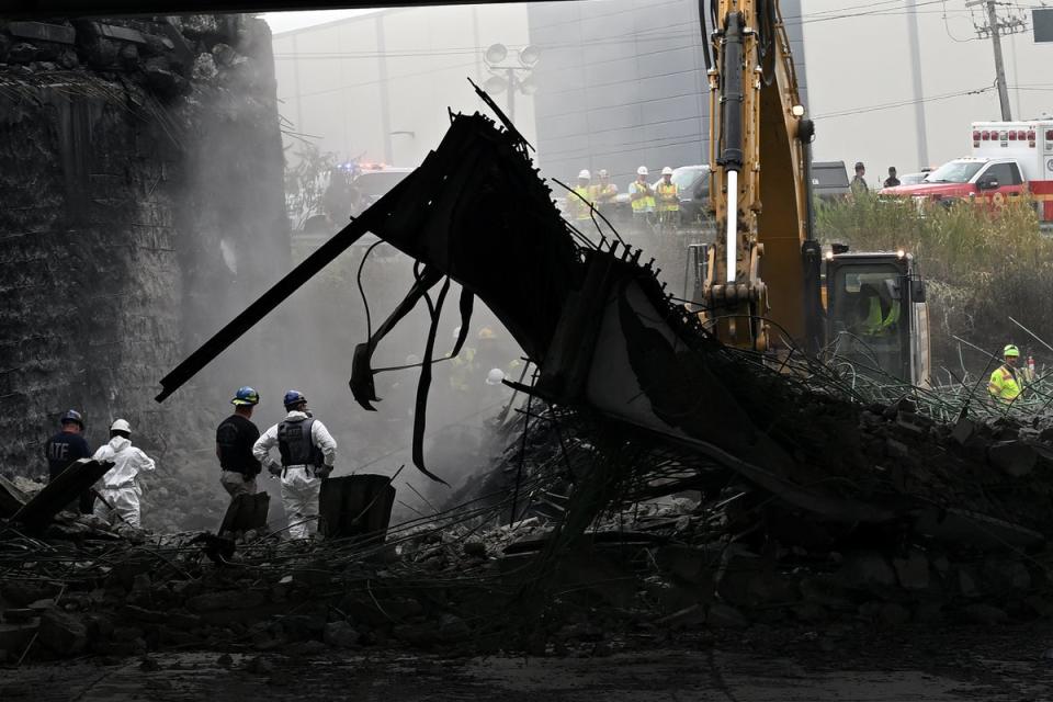 Workers inspect and clear debris from a section of the bridge that collapsed on Interstate 95 after an oil tanker explosion in Philadelphia, Pennsylvania (Getty)