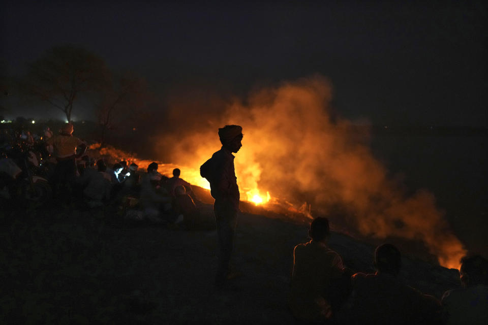 People cremate their relatives who died from heat-related illnesses, as a scorching heat wave overwhelmed hospitals and filled a morgue to capacity in Ballia, in the northern Indian state of Uttar Pradesh, Monday, June 19, 2023. (AP Photo/Rajesh Kumar Singh)