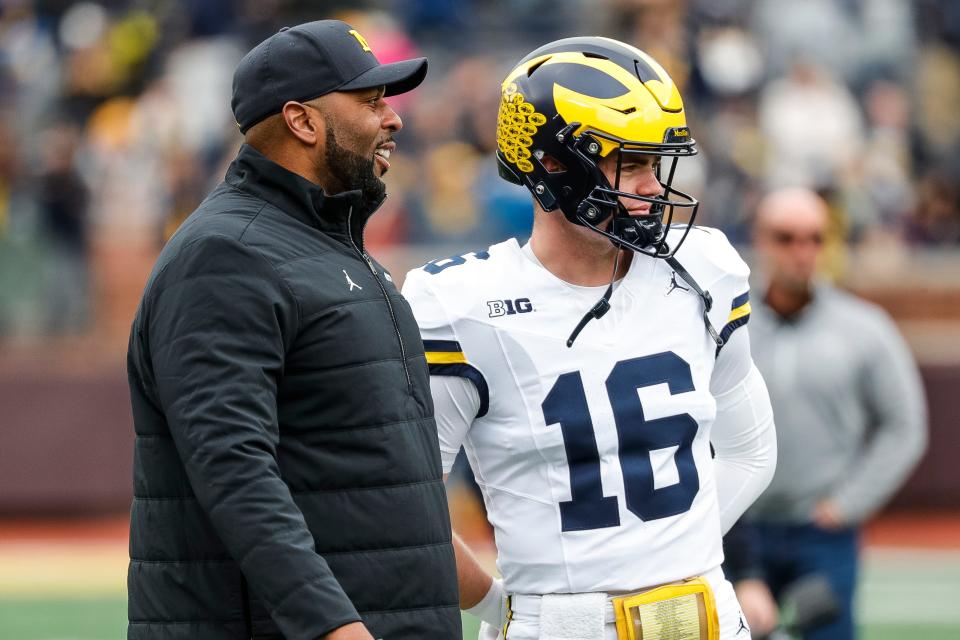 Michigan head coach Sherrone Moore talks to quarterback Davis Warren (16) at warmup during the spring game at Michigan Stadium in Ann Arbor on Saturday, April 20, 2024.