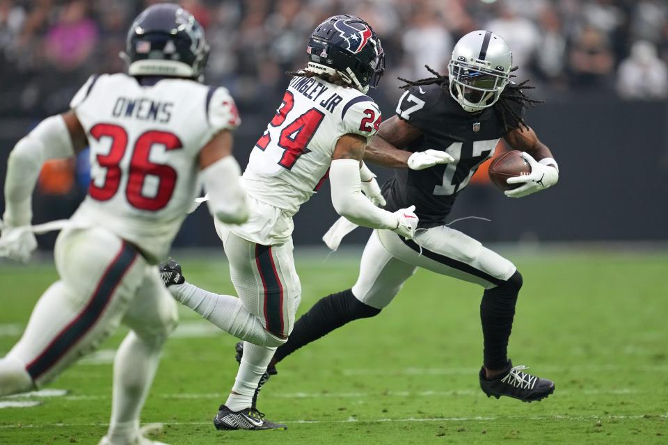 Las Vegas Raiders wide receiver Davante Adams (17) gains yardage as Houston Texans cornerback Derek Stingley Jr. (24) looks to make a tackle.