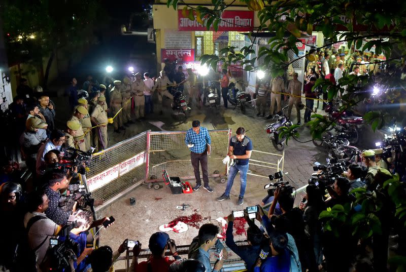 Forensic officials examine the spot where Atiq Ahmed and his brother Ashraf Ahmed were shot dead in Prayagraj