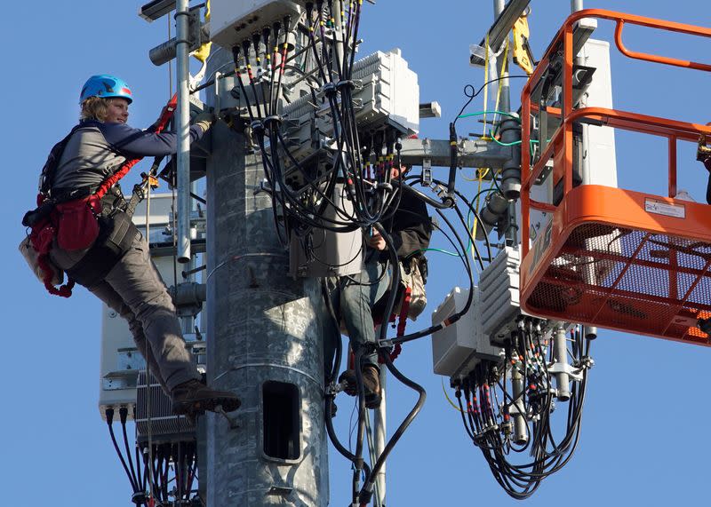 A crew from Verizon installs 5G equipment on a tower in Orem