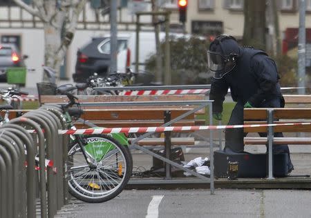 A French policemen inspects an abandoned suitcase in front of a building of Strasbourg's university, January 8, 2015, the day after a shooting at the Paris offices of Charlie Hebdo. REUTERS/Vincent Kessler