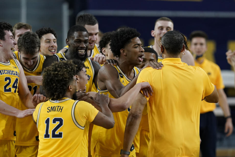 The Michigan bench congratulates head coach Juwan Howard, front right, after winning the Big Ten title against Michigan State in the second half of an NCAA college basketball game, Thursday, March 4, 2021, in Ann Arbor, Mich. (AP Photo/Carlos Osorio)