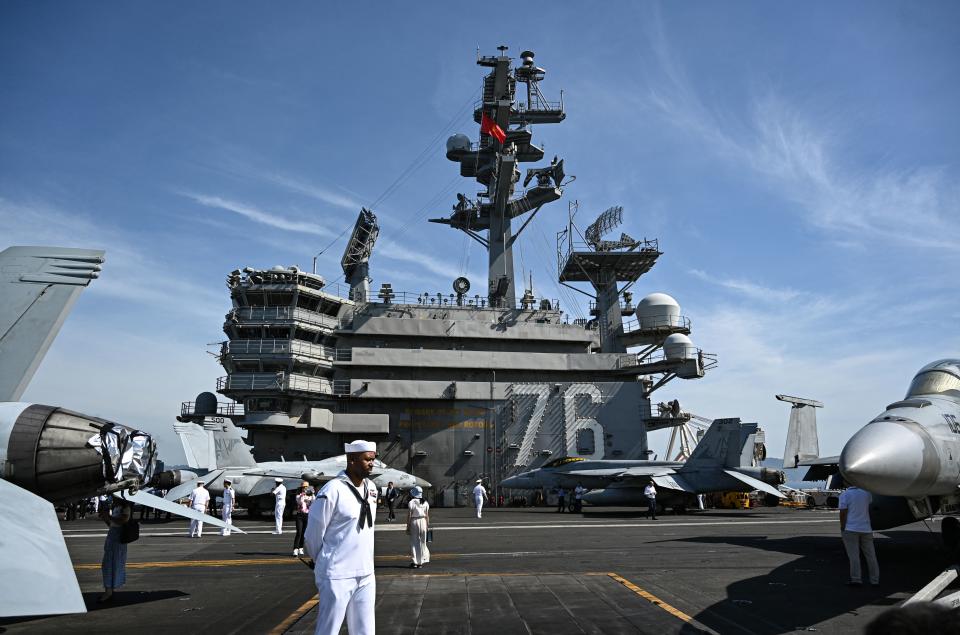 Los marineros están de pie en la cubierta del USS Ronald Reagan, un portaaviones nuclear de la Armada de los Estados Unidos de la clase Nimitz. (Foto de Nhac NGUYEN / AFP) (Foto de NHAC NGUYEN / AFP a través de Getty Images)