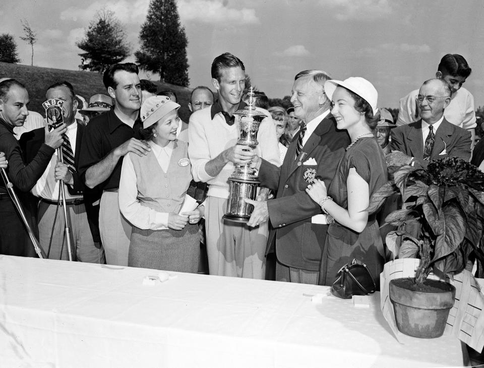 Golfer Charlie Coe, center, receives the National Amateur Golf Championship trophy in 1949.