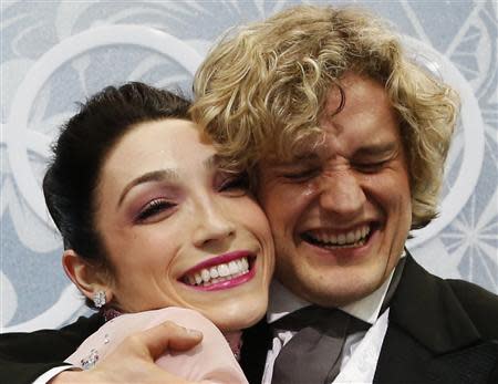 Meryl Davis and Charlie White of the U.S. celebrate in the "kiss and cry" area during the Figure Skating Ice Dance Short Dance Program at the Sochi 2014 Winter Olympics, February 16 2014. REUTERS/Lucy Nicholson