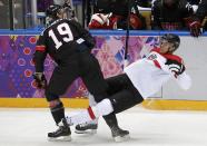 Canada's Jay Bouwmeester (L) hits Austria's Thomas Raffl during the first period of their men's preliminary round ice hockey game at the 2014 Sochi Winter Olympics, February 14, 2014. REUTERS/Jim Young (RUSSIA - Tags: OLYMPICS SPORT ICE HOCKEY)