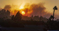 In this view from Newport Boulevard in North Tustin, the morning sun rises through the smoke of fire in the canyons east of North Tustin on Monday, Oct. 26, 2020. Firefighters were aggressively battling a vegetation fire that broke out in the hills near Silverado in Orange County as strong wind gusts pushed it. (Mark Rightmire/The Orange County Register via AP)