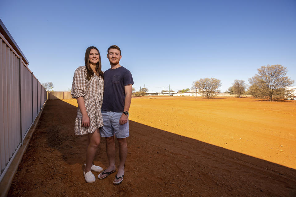 Tom Hennessy, right, and his fiancee Tessa McDougall stand on their land in the Australian Outback town of Quilpie, on Oct. 2, 2021. Quilpie had hoped its offer of a free residential block of land to anyone who would make it their home might attract five new families to the remote community of 800. But authorities have been overwhelmed by more than 250 enquires in less than two weeks from around Australia and internationally. (Leon O'Neil via AP)