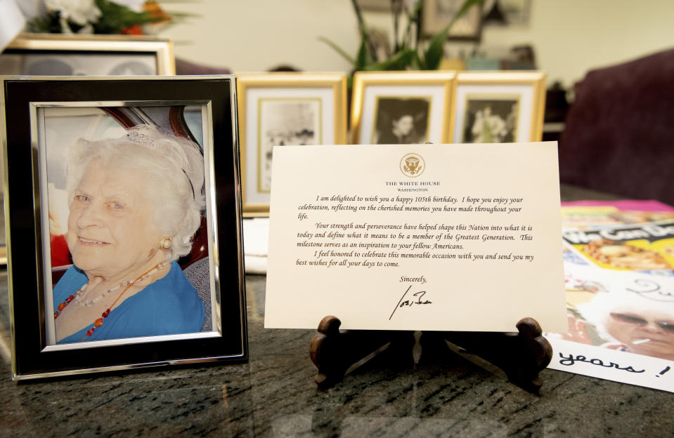 A note from President Joe Biden is seen placed among photos of Primetta Giacopini, who died of COVID-19 11 days prior in Richmond, Calif. on Monday, Sept 27, 2021. Primetta Giacopini's life ended the way it began — in a pandemic. She was two years old when she lost her mother to the Spanish flu in Connecticut in 1918. Giacopini contracted COVID-19 earlier this month. The 105-year-old struggled with the disease for a week before she died Sept. 16. (AP Photo/Josh Edelson)