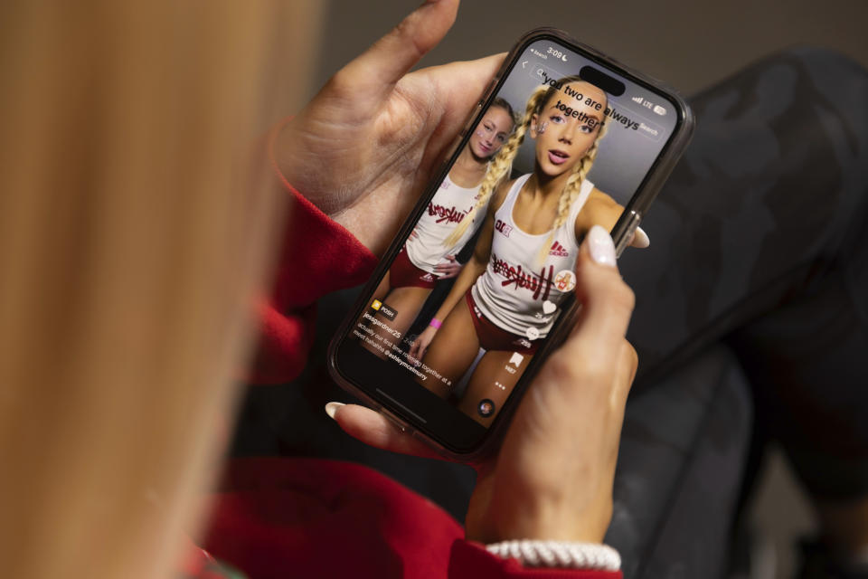 Nebraska NCAA college pole vaulter Jessica Gardner looks at her phone Thursday, March 9, 2023, in Lincoln, Neb. Making TikTok videos for fun evolved into a serious moneymaking venture for Nebraska track athlete Jess Gardner, who is among the many social media stars in college sports. (AP Photo/Rebecca S. Gratz)