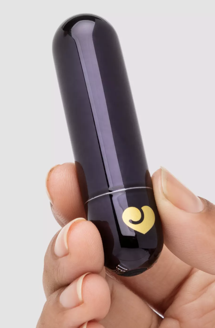 A model's hand holds a purple Lovehoney Glow Up Rechargeable Bullet Vibrator, $39.95 in her fingertips.