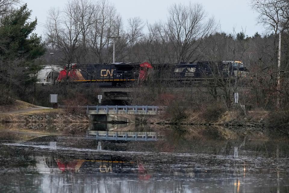A Norfolk Southern train travels near the East Palestine City Lake in East Palestine, Ohio, Feb. 11, 2023. About 50 Norfolk Southern train cars, several carrying hazardous materials, derailed in a fiery wreck on Feb. 3.