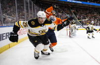 Boston Bruins defenseman Brandon Carlo (25) gets his stick in the face of Edmonton Oilers' Gaetan Haas (91) during the second period of an NHL hockey game, Wednesday, Feb. 19, 2020 in Edmonton, Alberta. (Jason Franson/The Canadian Press via AP)