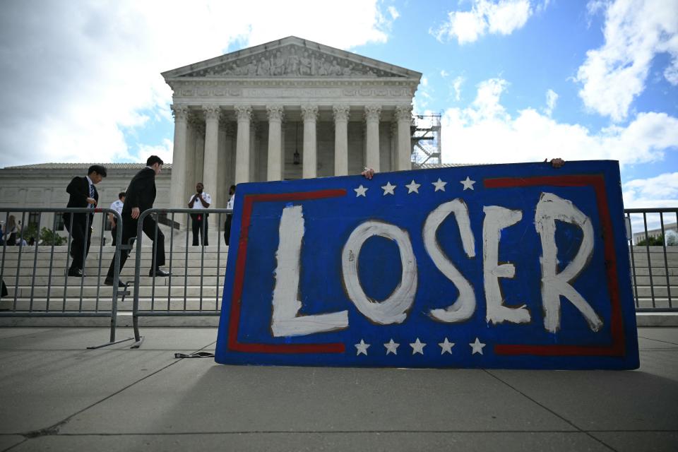 A placard that read "loser" is seen in front of the US Supreme Court on July 1, 2024, in Washington, D.C.