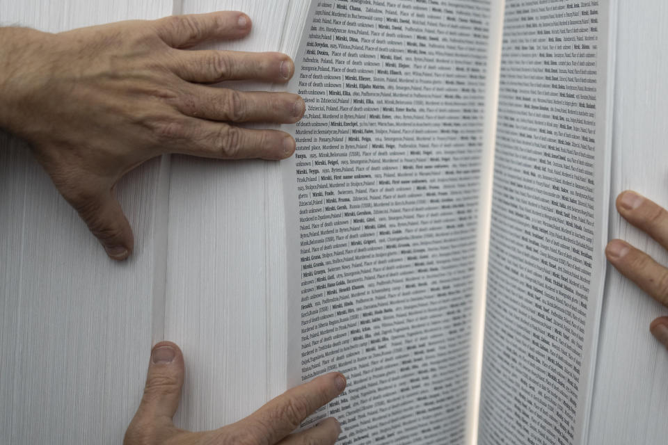 Gilad Erdan, Permanent Representative of Israel to the United Nations, Antonio Guterres, United Nations Secretary General, and Dani Dayan, Chairman of Yad Vashem, browse the Yad Vashem Book of Names of Holocaust Victims Exhibit, Thursday, Jan. 26, 2023, at United Nations headquarters. (AP Photo/John Minchillo)