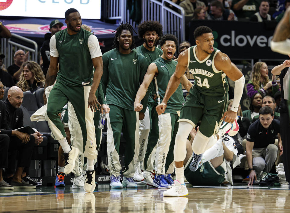 The Milwaukee Bucks bench reacts as Giannis Antetokounmpo (34) dunks against the Indiana Pacers during the first half of an NBA basketball game, Monday, Jan. 1, 2024, in Milwaukee. (AP Photo/Jeffrey Phelps)