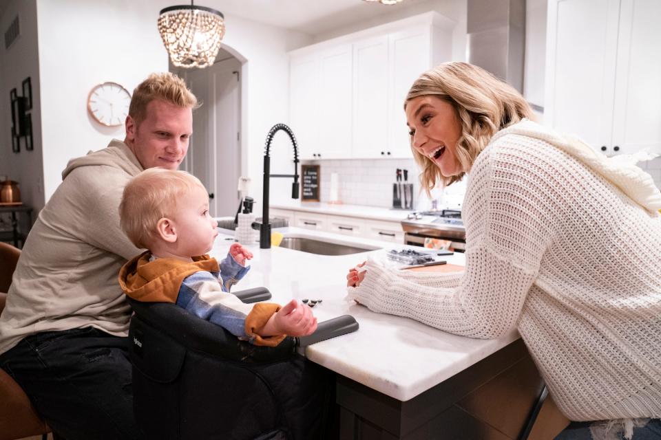 Recently retired NHL player Zach Trotman, left, looks on as Jeanna Trotman, the new weekend sports anchor and reporter at WXYZ in Detroit, prepares a snack for their 11-month-old son Luca  Tuesday, Nov. 16, 2021 at their Berkley home.