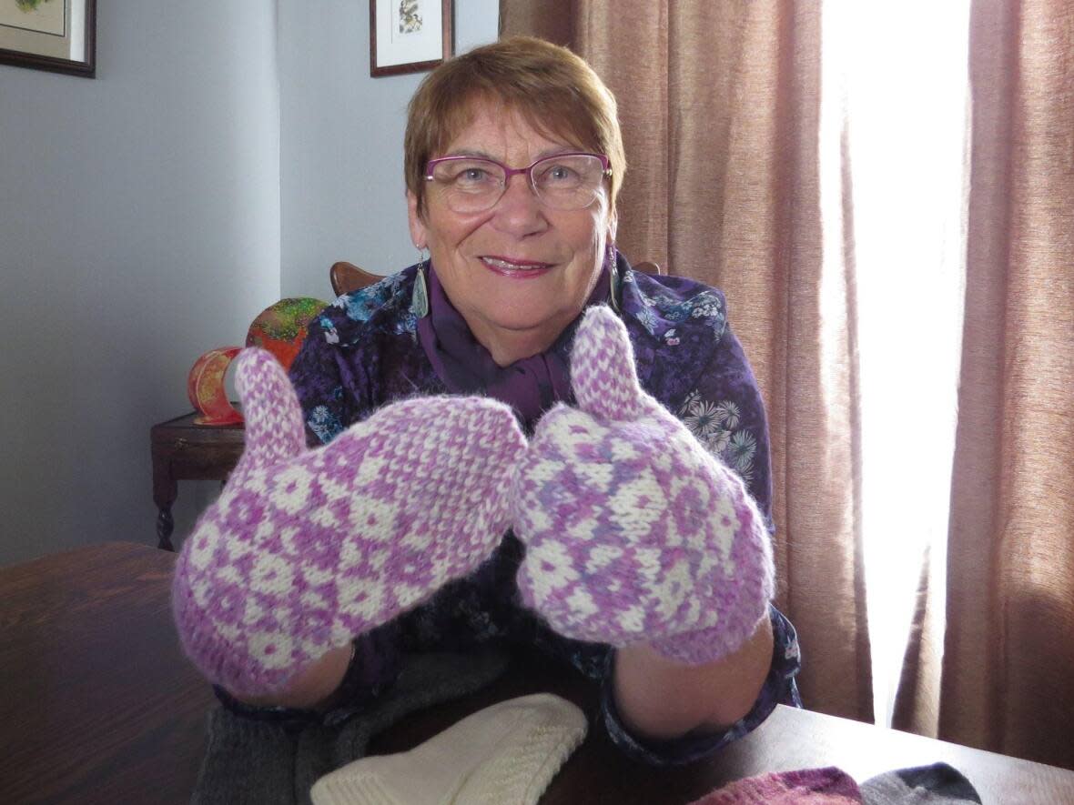 Christine LeGrow modeling trigger mittens made from the pink-dyed wool from Baynoddy, the craft shop and farm that Linda Lewis operates in Chapel’s Cove. (Elizabeth Whitten/CBC - image credit)