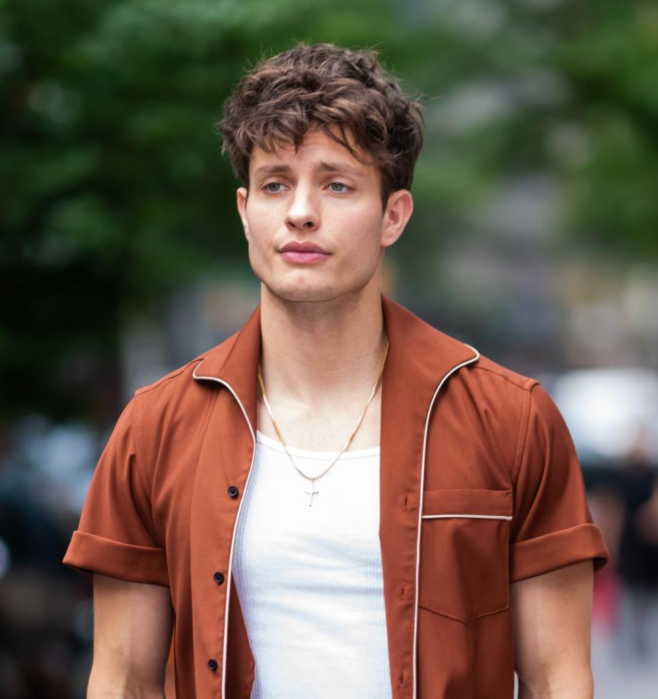 Matt Rife in monochrome outfit with open collared shirt, matching pants, and a tucked white T-shirt