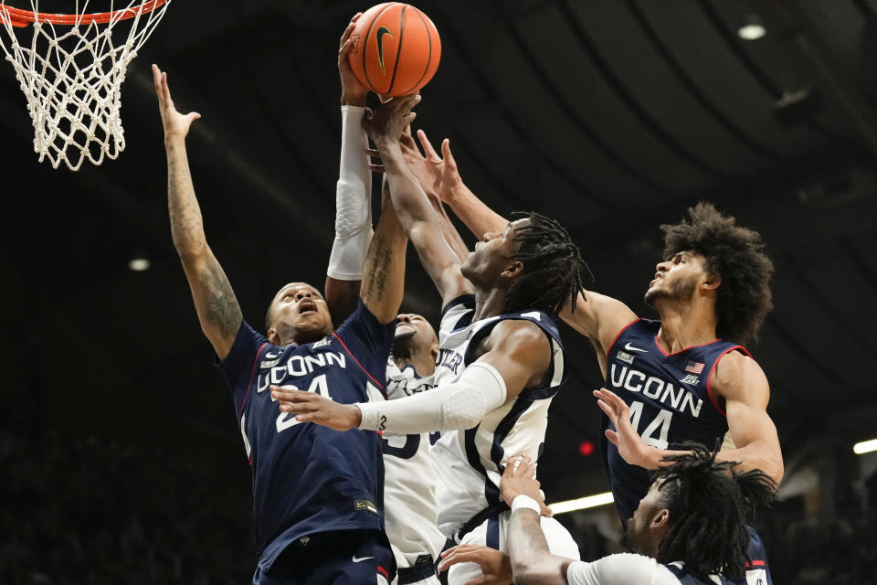 Connecticut's Jordan Hawkins, left, and Andre Jackson Jr., right, battle for a rebound with Butler guard Eric Hunter Jr., front center, in the second half of an NCAA college basketball game in Indianapolis, Saturday, Dec. 17, 2022. (AP Photo/AJ Mast)