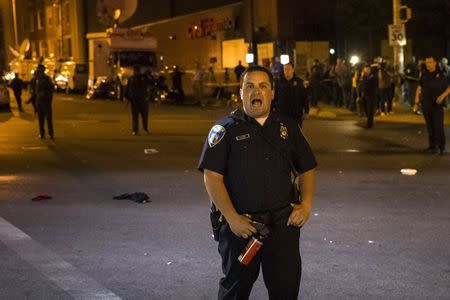 A police officer, holding pepper spray, shouts towards residents to leave the intersection of North Ave and Pennsylvania Ave after a 10 pm curfew in Baltimore, Maryland, May 2, 2015. REUTERS/Adrees Latif