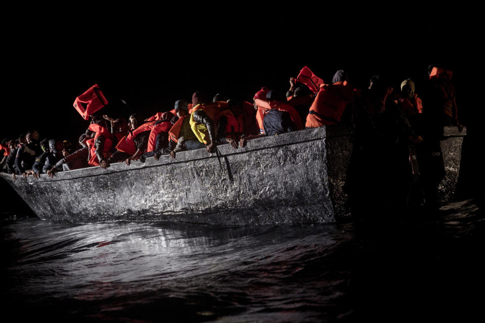 Dozens of migrants sit in a wooden boat adrift off the waters of Tunisia early Wednesday, May 25, 2022. Some 110 people were rescued by the non-governmental organization Open Arms during a mission in the Mediterranean Sea after their boat capsized. (AP Photo/Valeria Ferraro)