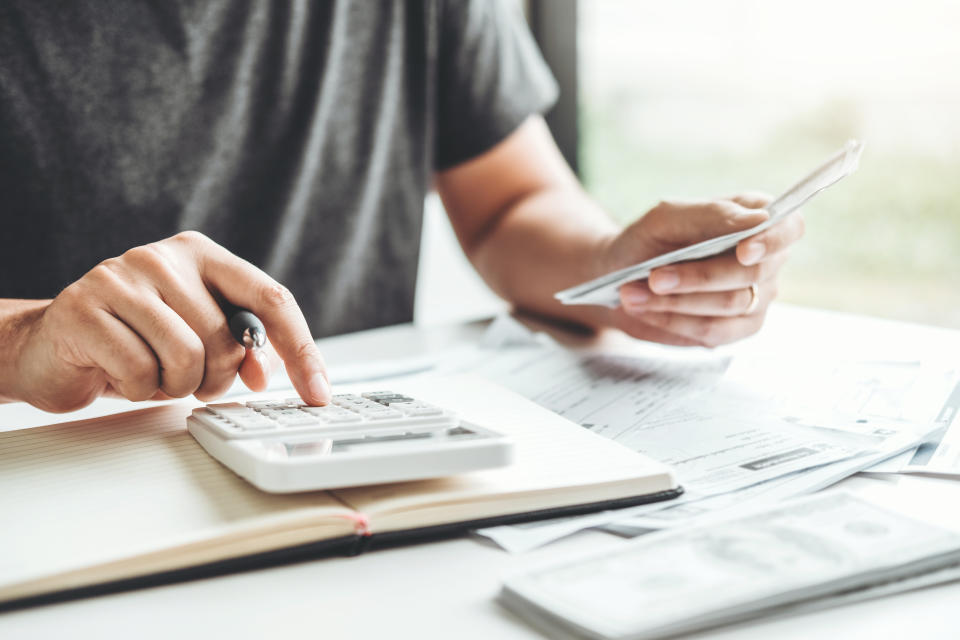 Man using calculator to add up budget