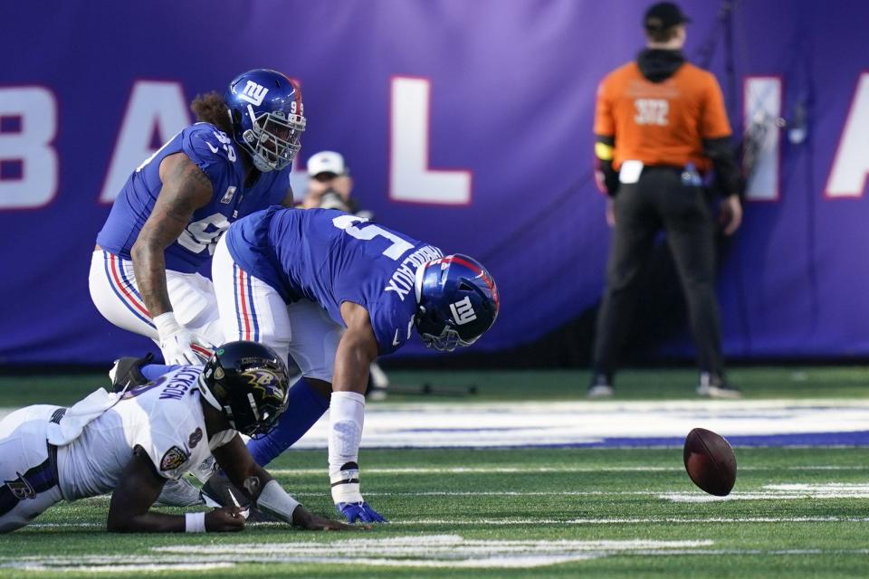 New York Giants Kayvon Thibodeaux (5), right, and Leonard Williams (99), top, chase a ball fumbled by Baltimore Ravens quarterback Lamar Jackson (8), bottom, during the second half of an NFL football game against the Baltimore Ravens, Sunday, Oct. 16, 2022, in East Rutherford, N.J. (AP Photo/Seth Wenig)