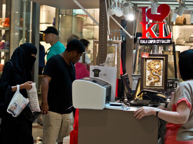 A tourist couple from Saudi Arabia shop at a mall in Kuala Lumpur on March 4, 2015