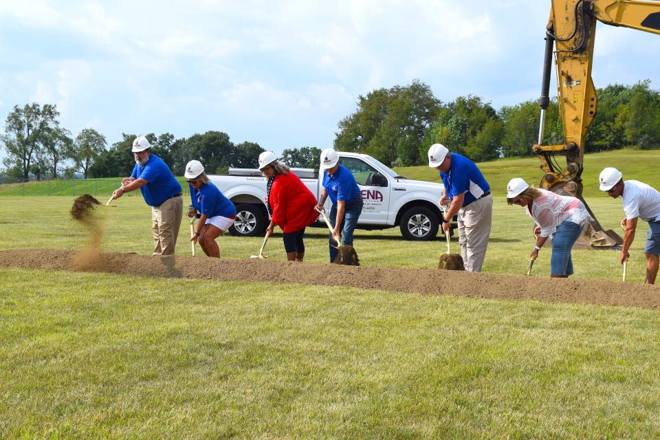 West Holmes Superintendent Eric Jurkovic, left, and West Holmes Local School board members dig and throw some dirt during a ceremony celebrating the opening of the new West Holmes Elementary School, behind West Holmes Middle and High Schools.