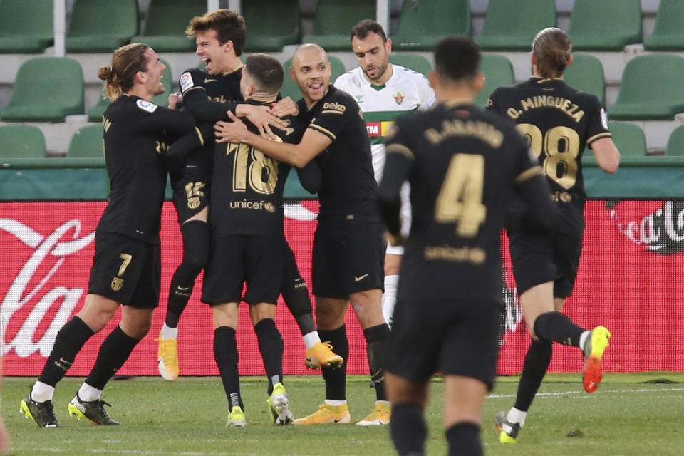 Riqui Puig (segundo a la izquiera) Frenkie de Jong festeja tras anotar el segundo gol del Barcelona en la victoria 2-0 ante Elche por La Liga española, el domingo 24 de enero de 2021, en Elche. (AP Foto/Alberto Saiz)