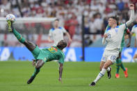 Senegal's Youssouf Sabaly, left, challenges with England's Phil Foden during the World Cup round of 16 soccer match between England and Senegal, at the Al Bayt Stadium in Al Khor, Qatar, Sunday, Dec. 4, 2022. (AP Photo/Hassan Ammar)