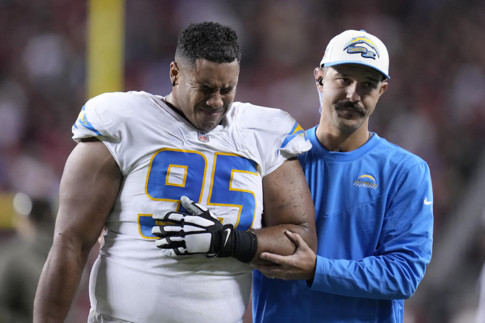 Los Angeles Chargers defensive tackle Christian Covington (95) is helped off the field during the second half of an NFL football game against the San Francisco 49ers in Santa Clara, Calif., Sunday, Nov. 13, 2022. (AP Photo/Godofredo A. Vásquez)